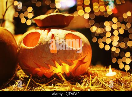 Sorridente zucca Jack o Lanterna seduta nel fieno. Foto Stock