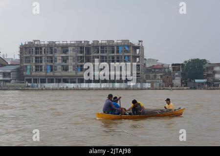 Pontianak, Indonesia - circa 2015: I residenti che attraversano il fiume Kapuas utilizzando una piccola barca di legno durante lo smog causato da un incendio terrestre. Foto Stock