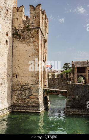 Torre del Castello Scaligero a Sirmione. Canale d'acqua del Lago di Garda con Fortezza nel Nord Italia. Foto Stock