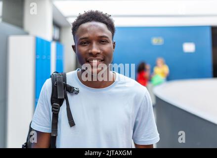 Ritratto di un giovane studente afro-americano in piedi nel corridoio delle scuole superiori Foto Stock