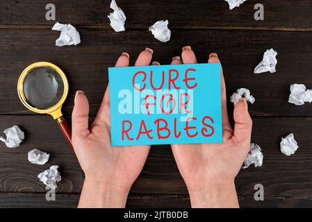 Segno di testo che mostra Cure for Rabbies. Panoramica commerciale vaccinazione farmaci per combattere la malattia letale virus Man Holding A Tablet proietta A. Foto Stock