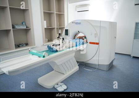 Il paziente nel centro medico si trova nella camera del tomografo Foto Stock