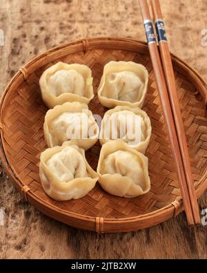 Primo piano Ravioli Jiaozi Shuijiao, cinese al vapore, su rustico sfondo di legno Foto Stock