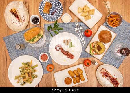 Set di piatti di ricette spagnole e tapas dal tocco moderno, frittelle di merluzzo, crocchette di prosciutto, polpo galiziano, sandwich di calamari, torrezno odoroso Foto Stock