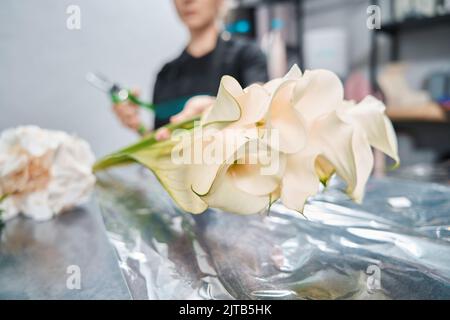 Sul banco in negozio di fiori si trova bouquet di gigli calla Foto Stock