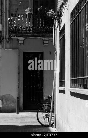 Una bicicletta parcheggiata in una strada stretta a Barrio de Gracia, Barcellona Foto Stock