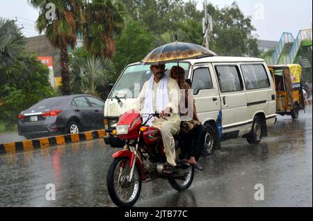 Sukkur, Pakistan, 29 agosto 2022. I pendolari stanno attraversando una strada durante il pesante defluire della stagione monsonica, a GT strada a Gujranwala Lunedi, 29 agosto 2022. Foto Stock