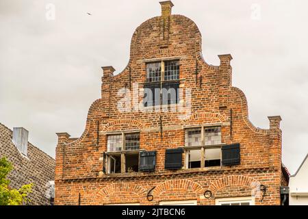 Deventer, Paesi Bassi. Un bel timpano olandese in mattoni con gatto decorativo nella finestra Foto Stock