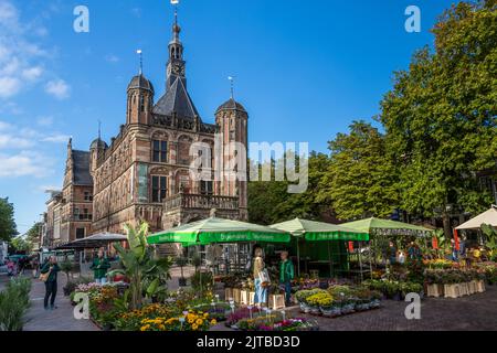 Mercato settimanale di fronte alla casa di scala a Deventer, Paesi Bassi. La più antica casa di pesatura dei Paesi Bassi del 1528 si trova sulla piazza De Brink. Le scale della città hanno avuto una grande importanza per la vita commerciale. I mercanti dovevano far pesare le loro merci sotto la supervisione delle autorità cittadine. Le tasse e i pedaggi contribuirono alla ricchezza del Deventer. Foto Stock