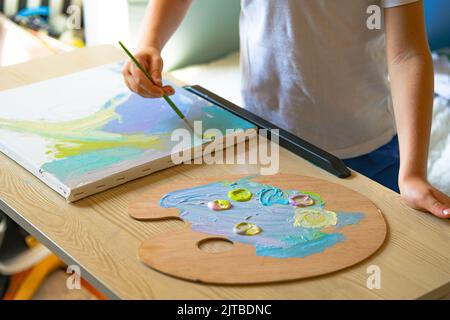 Pittura bambino su tela con pittura acrilica. Foto Stock