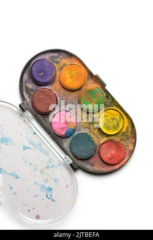 primo piano di una scatola di vernici acquerello usate e sporche, isolate su sfondo bianco, prese direttamente dall'alto, concetto di lavoro dell'artista Foto Stock
