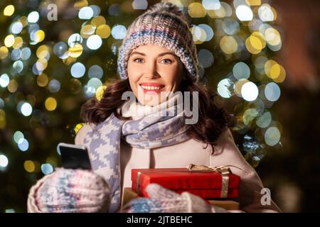 donna felice con regali di natale e smartphone Foto Stock