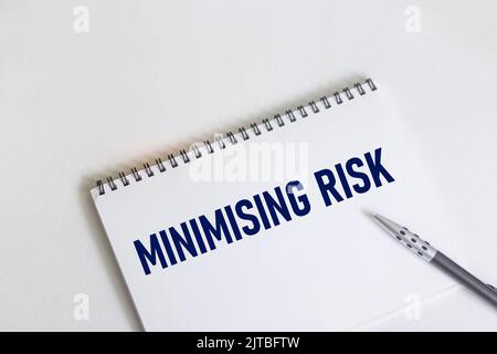 MINIMIZZAZIONE del TESTO DEI RISCHI su blocco note, carta da lavoro. Concetto commerciale e finanziario. Foto Stock