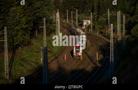 Treno elettrico passeggeri che arriva alla stazione Strba in Slovacchia montani in estate mattina di sole Foto Stock