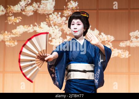 Una geisha giapponese che indossa un kimono, esegue una tradizionale danza dei tifosi presso il Santuario di Kanda Myojin, a Chiyoda, Tokyo, Giappone. Foto Stock