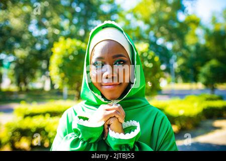 Ritratto di una bella sposa musulmana latino ispanica con make up in abito da sposa verde nel parco estivo Foto Stock