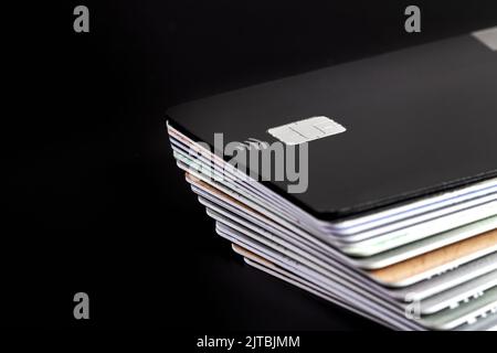 Una pila di carte di credito bancarie su sfondo scuro Foto Stock