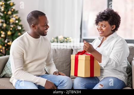 felice coppia africana con regalo di natale a casa Foto Stock