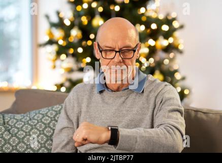 uomo anziano che guarda a casa a natale Foto Stock