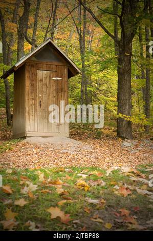 Wood Outhouse in un parco nazionale durante la stagione autunnale verticale Foto Stock