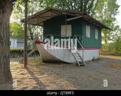 Italia, Lombardia. Casa galleggiante trasportata sulla riva del po per essere utilizzata come sede di un club ricreativo. Foto Stock