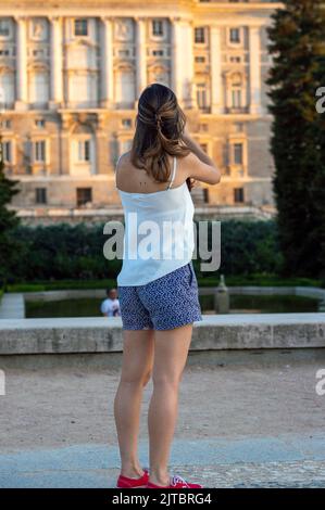 Una giovane donna in pantaloncini blu e una blusa bianca che cammina attraverso i Jardines di Sabatini a Madrid Foto Stock