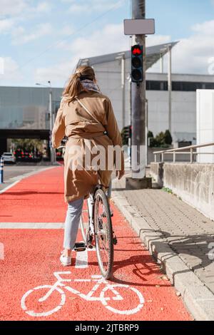 donna in bicicletta in attesa del semaforo verde Foto Stock