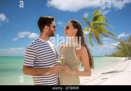 felice coppia bevendo champagne sulla spiaggia esotica Foto Stock