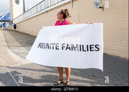 Flushing, New York, USA. 29th ago, 2022. Donna con un segno che dice ''riunisci le famiglie'' per una protesta contro l'Open degli Stati Uniti contro i mandati di viaggio correlati alla pandemia (Credit Image: © Michael Brochstein/ZUMA Press Wire) Foto Stock