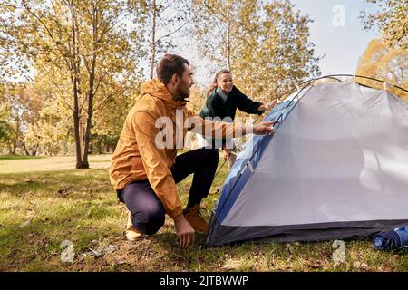 Coppia felice impostazione di tenda all'aperto Foto Stock