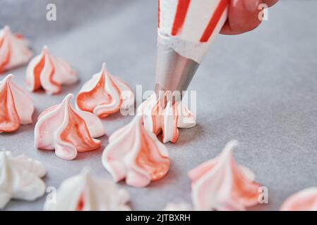 Processo di preparazione di meringa fatta in casa, donna che cucina la crema dolce per dessert su foglio di cottura Foto Stock