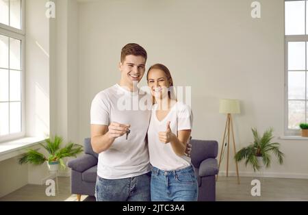 Ritratto di felice giovane famiglia gioiosa che è felice di comprare casa e spostare in nuovo appartamento. Foto Stock