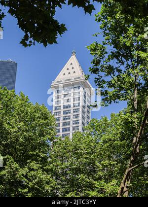 Seattle USA - Luglio 20 2008; la Smith Tower, in stile architettonico neoclassico, si innalza verso il cielo incorniciato da alberi urbani Foto Stock