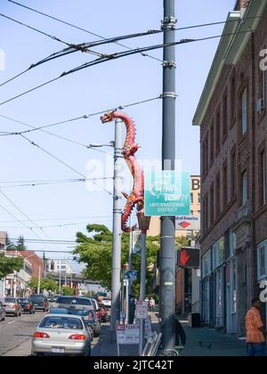 Seattle USA - Luglio 20 2008; Urban Street nella zona di China Town con grande drago rosso arrampicata strada palo luce. Foto Stock