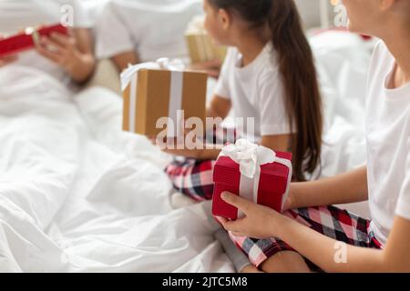 famiglia felice con i regali di natale nel letto a casa Foto Stock