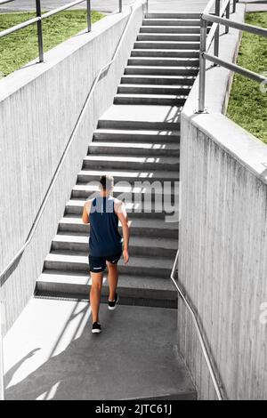 giovane uomo che corre al piano superiore Foto Stock