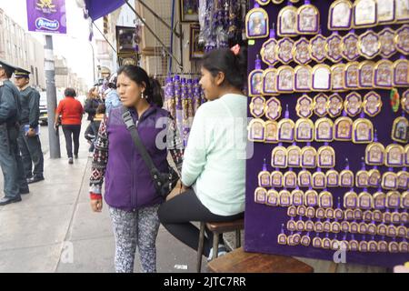 Due donne che vendono articoli religiosi davanti alla chiesa del Signore dei Miracoli. Foto Stock