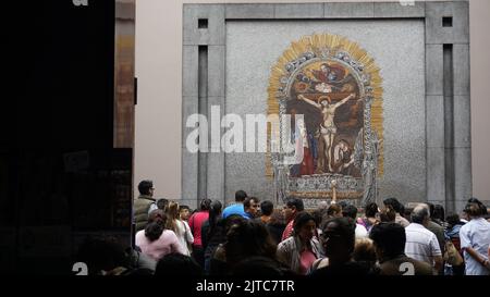 Persone che cercano di avvicinarsi a un'immagine del Signore dei Miracoli che porta l'offerta e chiede il suo aiuto. Foto Stock