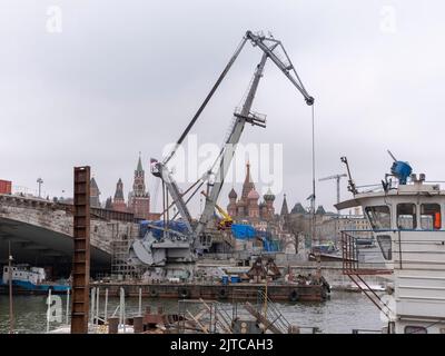 MOSCA, RUSSIA - 01 maggio 2021: Gru da cantiere con un boom esteso vicino al Ponte di pietra sul fiume Mosca, sullo sfondo del Foto Stock