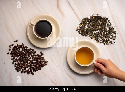 Fotografia alimentare di tè verde, caffè, fagioli, scelta, mano Foto Stock