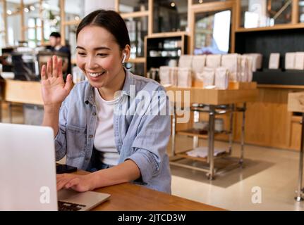 Giovane studentessa asiatica che usa videochiamate con laptop e che ha una riunione virtuale. Foto Stock