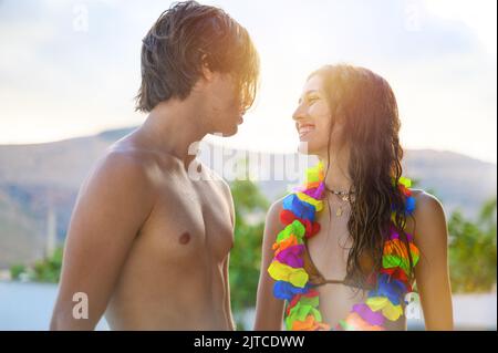 Una coppia felice si gode l'estate in una piscina Foto Stock