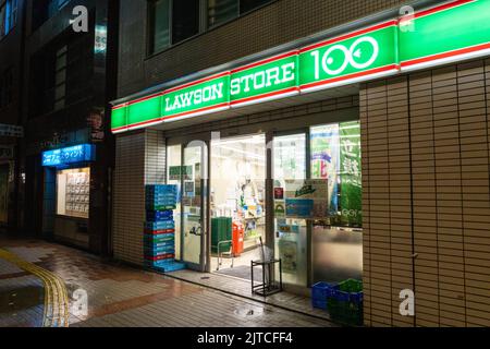 Vista notturna di un Lawson 100 Store, uno dei migliaia di minimarket di Tokyo, Giappone. I minimarket del quartiere hanno avuto origine in Ohio, ma oggi esiste come azienda giapponese con quasi 12.000 negozi in tutta l'Asia. Foto Stock