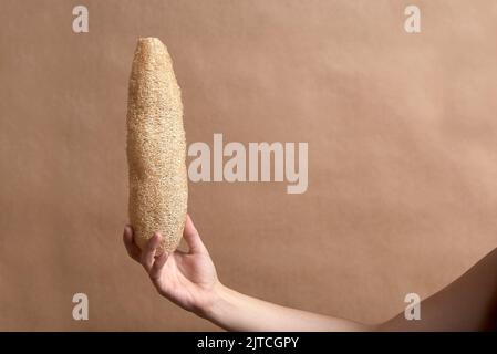 Giovane mano femminile che tiene una loofah, spugna vegetale ecologica biodegradabile. Concetti: Stile di vita sostenibile, scelta di pro rispettoso dell'ambiente Foto Stock