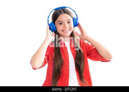 Adolescente con moderne cuffie wireless che ascolta la sua musica preferita su sfondo bianco da studio. Felice adolescente Foto Stock