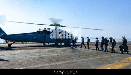 220827-N-FB730-1034 IONIAN SEA (AGO. 27, 2022) marinai della portaerei di classe Nimitz USS Harry S. Truman (CVN 75), a bordo di un elicottero MH-60s Sea Hawk, attaccato ai 'Night Dippers' di Helicopter Sea Combat Squadron (HSC) 5, per transitare verso la portaerei di classe Nimitz USS George W Bush (CVN 77) Per visitare i familiari assegnati al Bush, 27 agosto 2022. Il gruppo Harry S. Truman Carrier Strike Group è in fase di implementazione pianificata nell'area operativa delle forze navali europee degli Stati Uniti, impiegata dalla U.S. Sesta flotta per difendere gli interessi degli Stati Uniti, alleati e partner. (STATI UNITI Foto Navy di Mass Commun Foto Stock