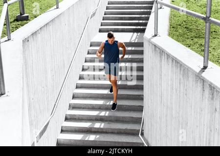 giovane uomo che corre al piano di sotto Foto Stock