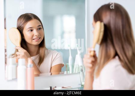 ragazza adolescente spazzolare i capelli con pettine in bagno Foto Stock