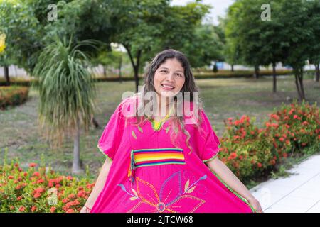 Donna colombiana che indossa abiti tradizionali in un parco Foto Stock