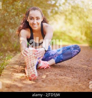 Incorpora una serie di riscaldamento prima di allenarti. Una giovane donna sportiva che si allunga prima della corsa. Foto Stock